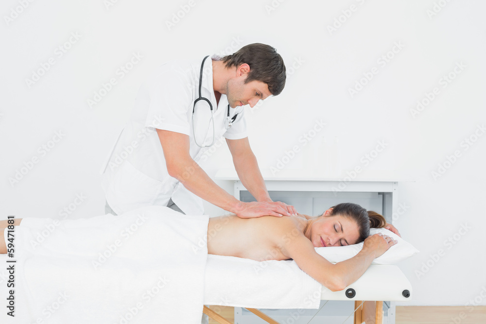 Male physiotherapist massaging woman's back Male physiotherapist massaging woman's back