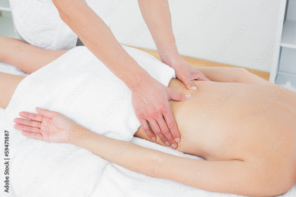 Mid section of a physiotherapist massaging woman's back Mid section of a physiotherapist massaging woman's back