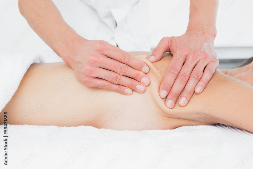 Mid section of a physiotherapist massaging woman's body Mid section of a physiotherapist massaging woman's body