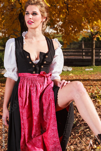 Träumende junge Frau in einem traditionellen Dirndl photo