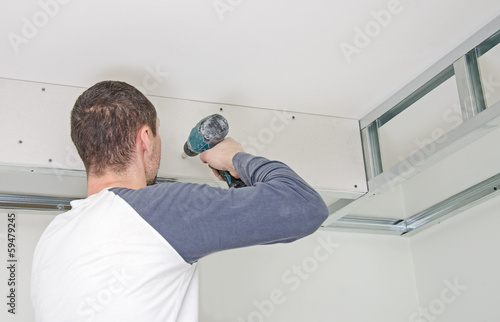 Quadro em tela Builder mounting gypsum plasterboard frame on the wall