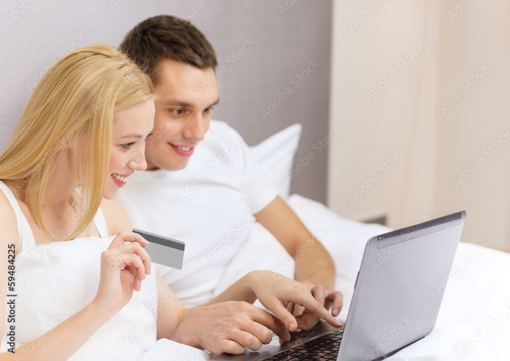 couple in bed with laptop computer and credit card couple in bed with laptop computer and credit card