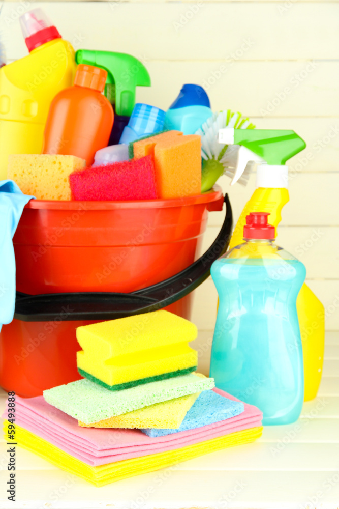 Cleaning items in bucket on white wooden background Cleaning items in bucket on white wooden background