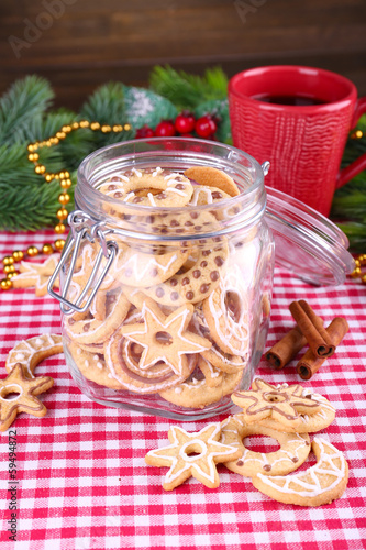Delicious Christmas cookies in jar on table on wooden