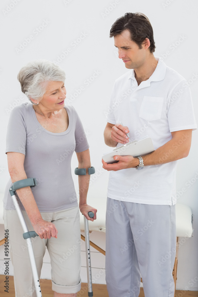 Fototapeta premium Therapist discussing reports with a disabled senior patient