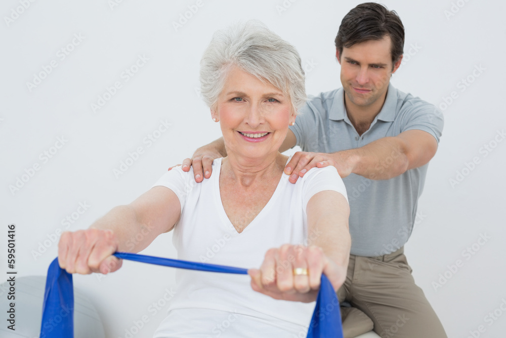 Obraz premium Male therapist assisting senior woman with exercises