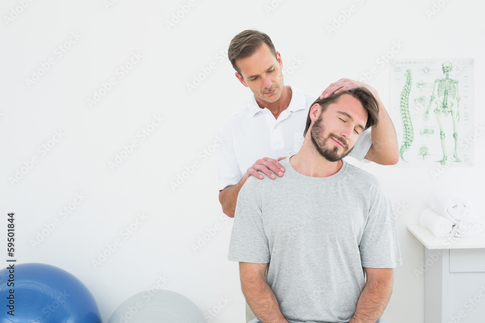 Male chiropractor doing neck adjustment - obrazy, fototapety, plakaty 