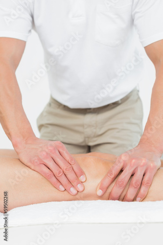 Physiotherapist examining a young woman's leg