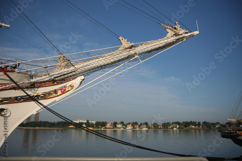 Bowsprit of a sail ship with city in the background photo