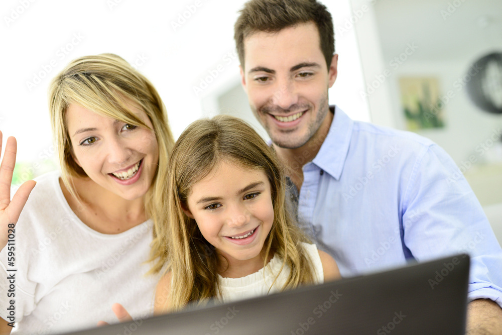 Family having fun chating on internet with laptop Family having fun chating on internet with laptop