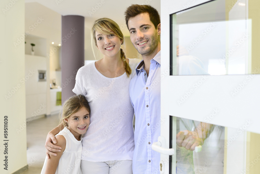 Family standing at front door to invite people in Family standing at front door to invite people in