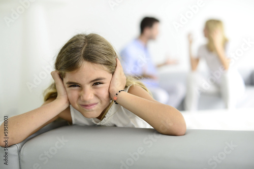 Little girl tired of earing her parents yelling at each other photo