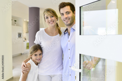 Family standing at front door to invite people in