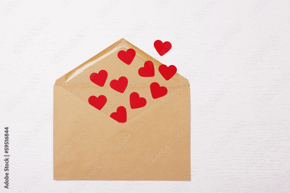 brown envelope with red paper hearts inside