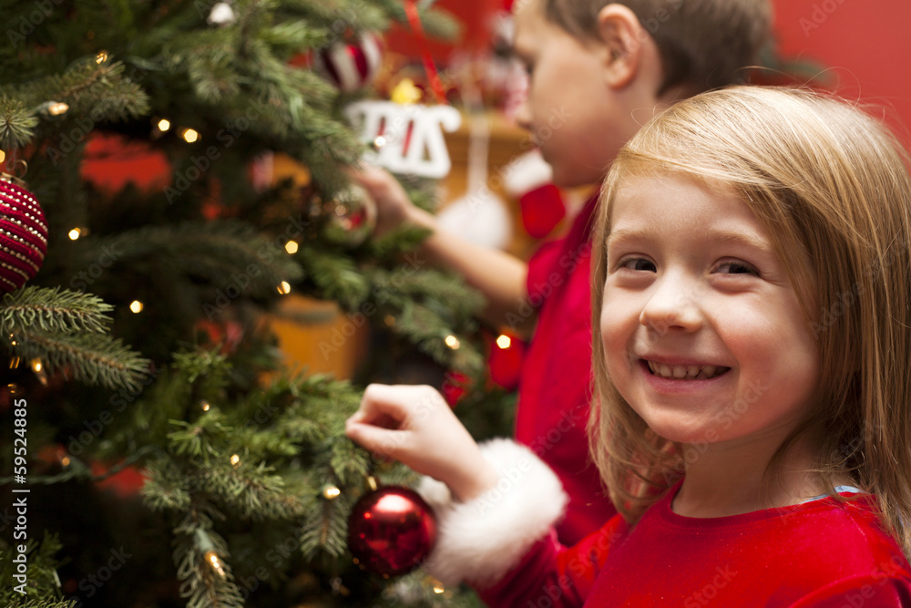 Happy children decorating Christmas tree