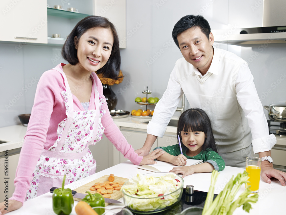 Naklejka premium happy asian family in kitchen