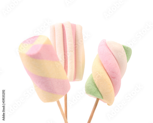Three different marshmallow on sticks.