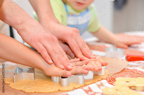 Close up little hands making the gingerbread cookies