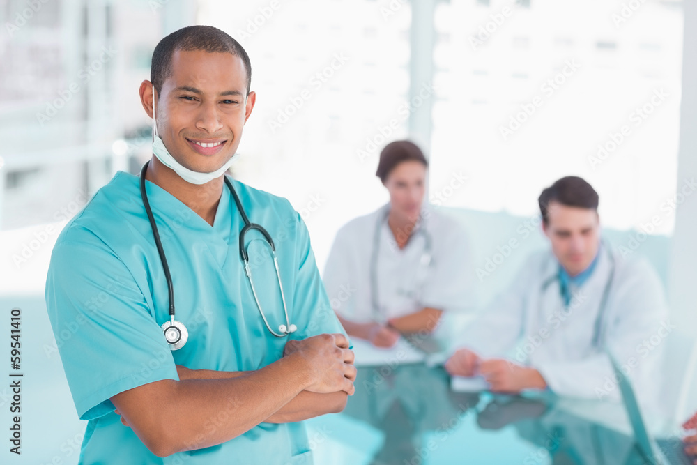 Surgeon standing with group around table in hospital Surgeon standing with group around table in hospital