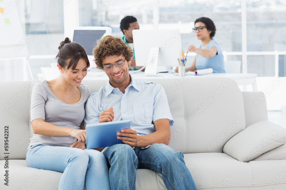 Couple using digital tablet with colleagues at creative office Couple using digital tablet with colleagues at creative office