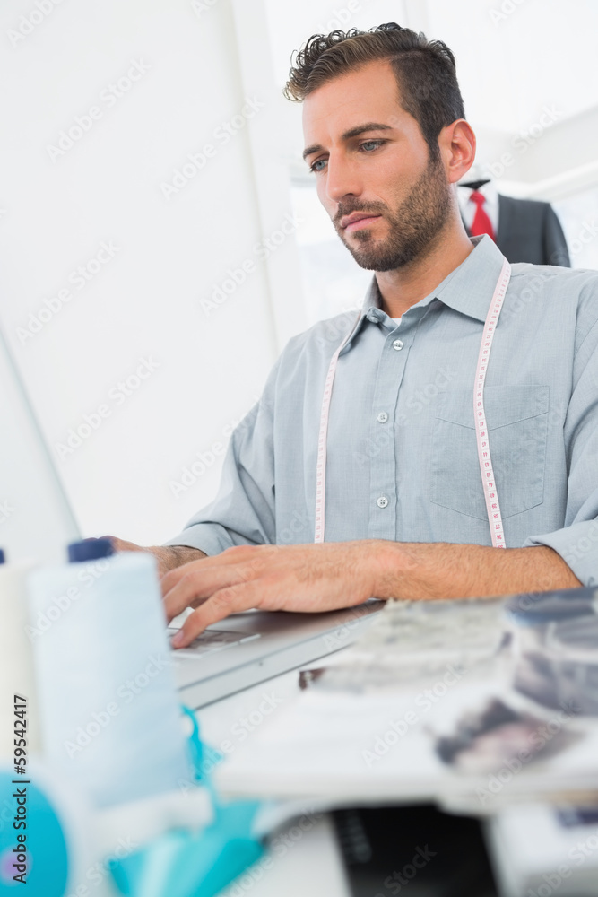 Young male fashion designer using laptop Young male fashion designer using laptop