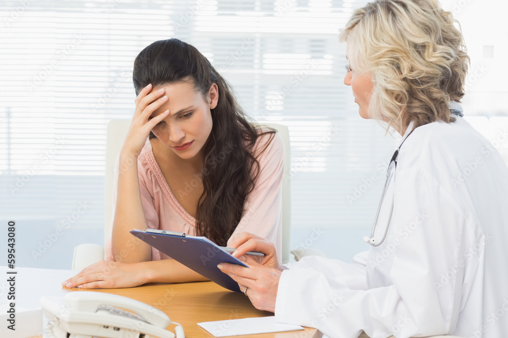 Female doctor discussing reports with patient Female doctor discussing reports with patient
