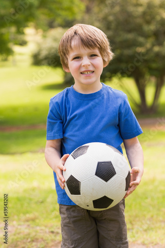Smiling young boy holding ball in park © WavebreakMediaMicro