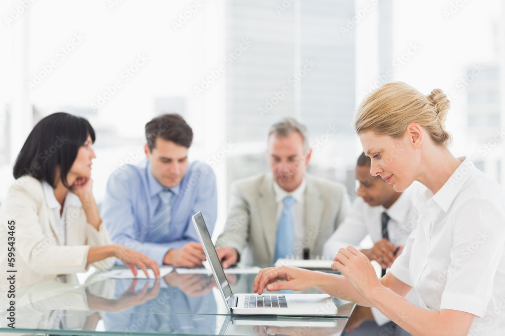 Businesswoman using her laptop during a meeting Businesswoman using her laptop during a meeting
