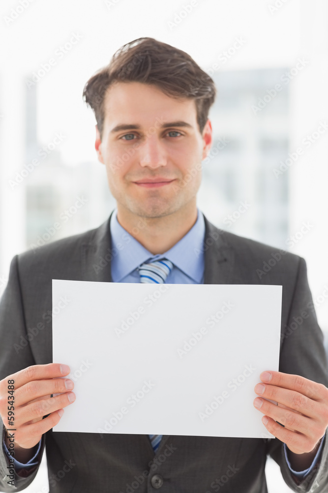 Smiling businessman holding blank page Smiling businessman holding blank page