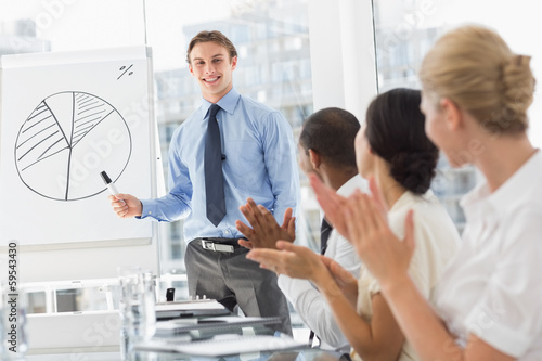 Colleagues applauding businessman after presentation
