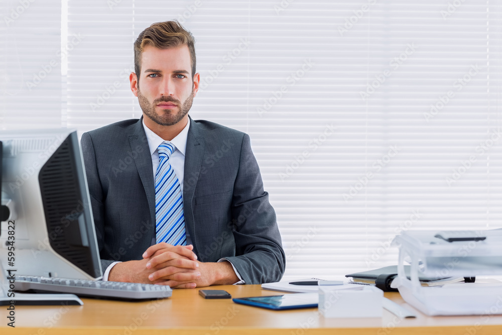 Serious businessman with computer at office desk Serious businessman with computer at office desk