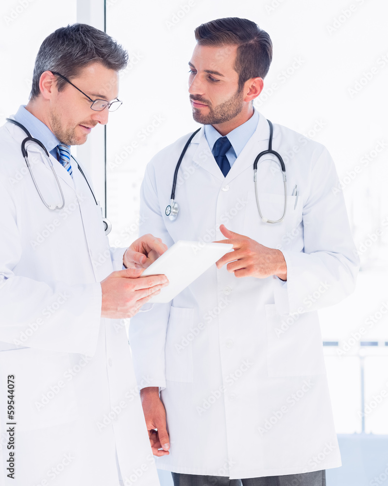 Male doctors using digital tablet in medical office Male doctors using digital tablet in medical office