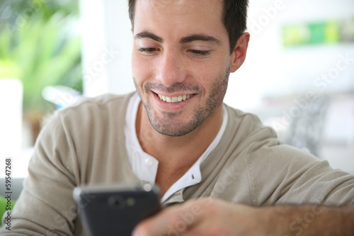Man at home connected on smartphone