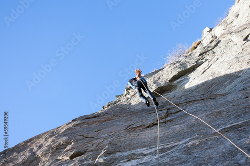 A rock climber abseiling off a climb