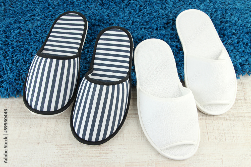 Striped and white slippers on floor background Striped and white slippers on floor background
