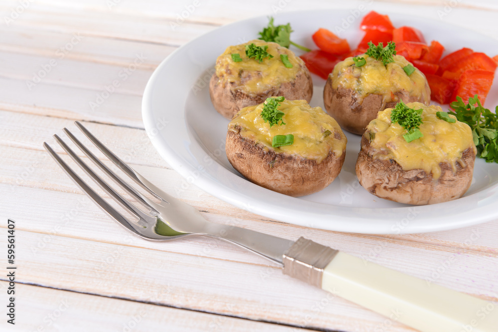 Stuffed mushrooms on plate on table on light background Stuffed mushrooms on plate on table on light background