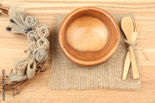 Rustic table setting with plate, fork and spoon, on wooden