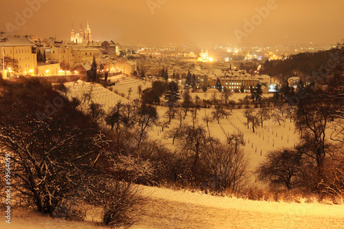 Night snowy Prague City with gothic Castle, Czech republic