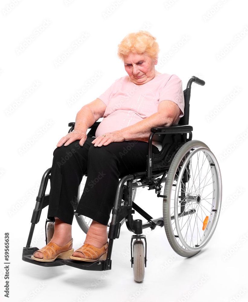 Elderly paraplegic woman sitting in a wheelchair on a white. Elderly paraplegic woman sitting in a wheelchair on a white.