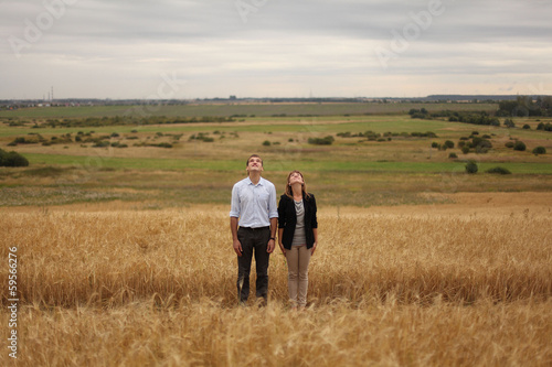 young man and woman walking in a field of wheat © kichigin19