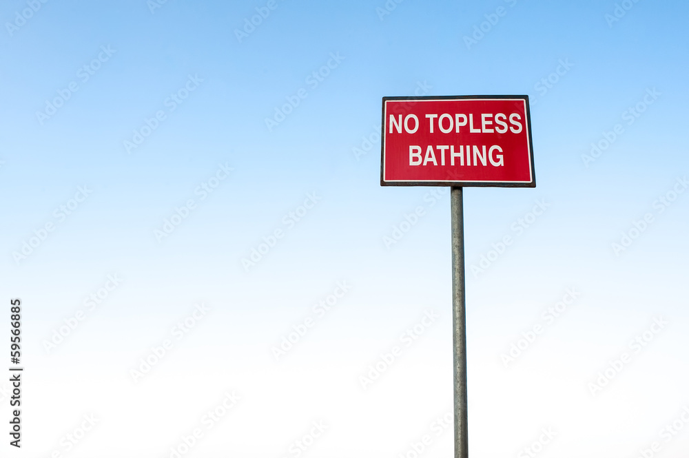 No topless bathing sign post against clear blue sky No topless bathing sign post against clear blue sky