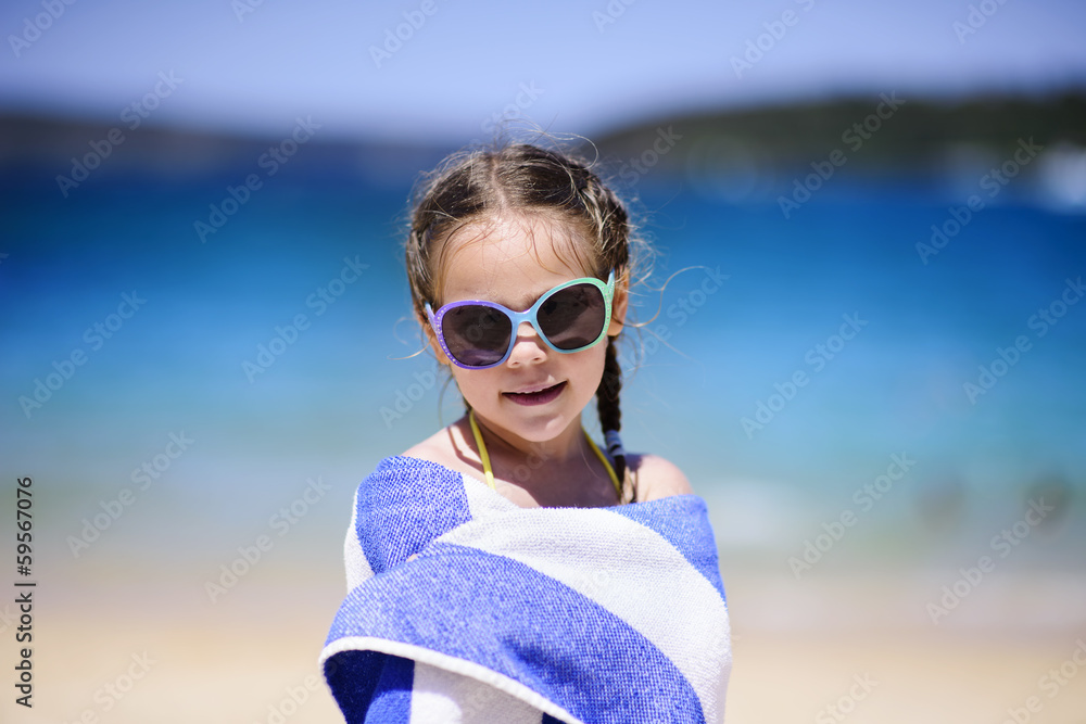 Cute little girl at tropical beach covered with towel Cute little girl at tropical beach covered with towel