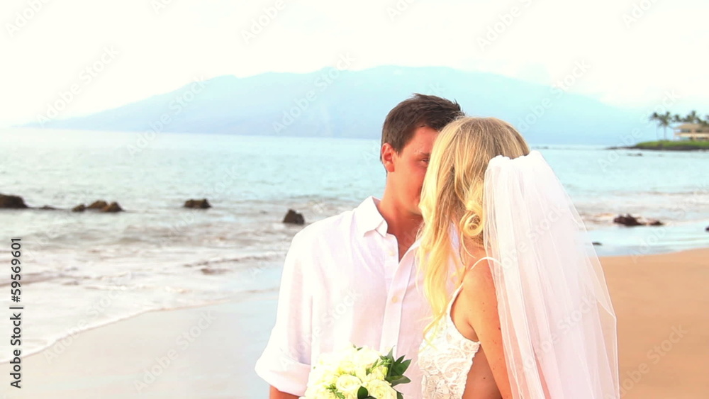 Newly married couple on tropical beach after sunset wedding Newly married couple on tropical beach after sunset wedding