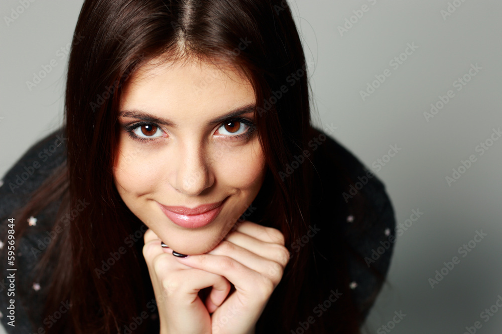 Closeup portrait of a young happy woman on gray background Closeup portrait of a young happy woman on gray background