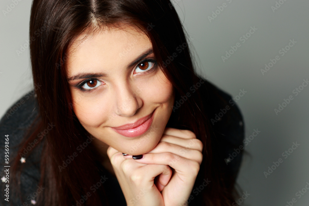 Closeup portrait of a young cheerful woman on gray background Closeup portrait of a young cheerful woman on gray background