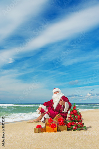 Santa Claus at sea beach with many gifts and decorated christmas