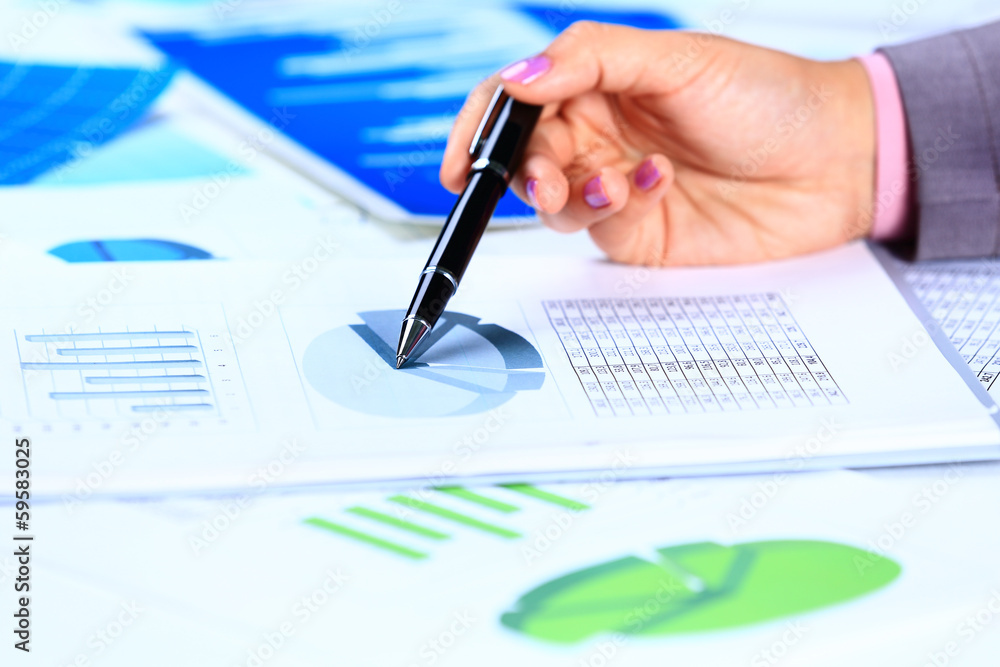 Close up of female hands reviewing accounting documents Close up of female hands reviewing accounting documents