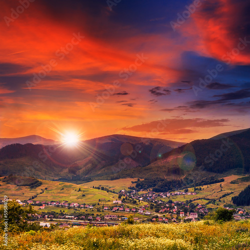 evening light  beam falls on hillside with autumn village in mou photo