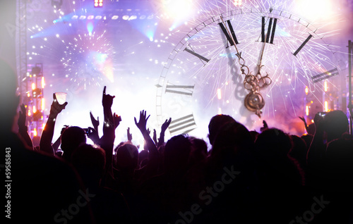 Clock close to midnight, fireworks and crowd waiting for New yea