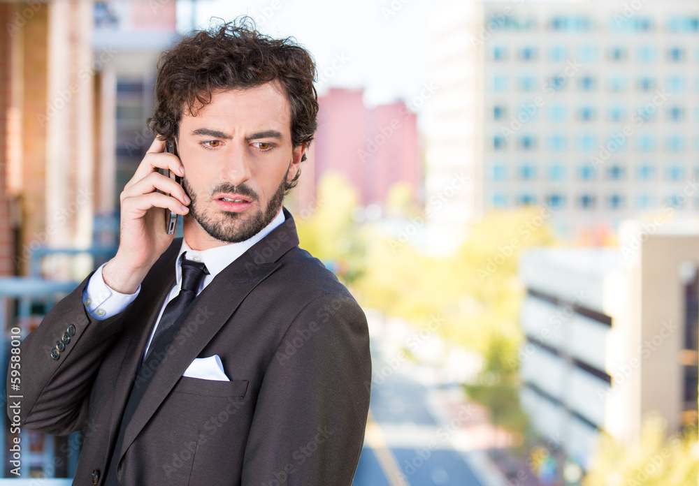 Businessman talking on a phone, on a balcony of his apartmentt Businessman talking on a phone, on a balcony of his apartmentt